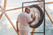 © ADDICTIVE STOCK - Spiritual man hitting gong