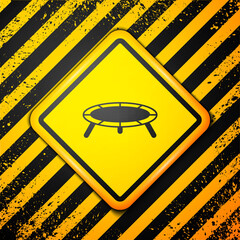 Sticker - Black Jumping trampoline icon isolated on yellow background. Warning sign. Vector