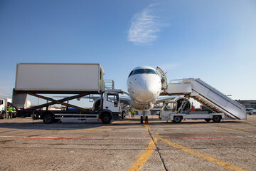 Boarding passengers on the plane. Boarding bridge. The plane lands at the international airport. Loading luggage. White airplane. Terminal Runway. Copy space