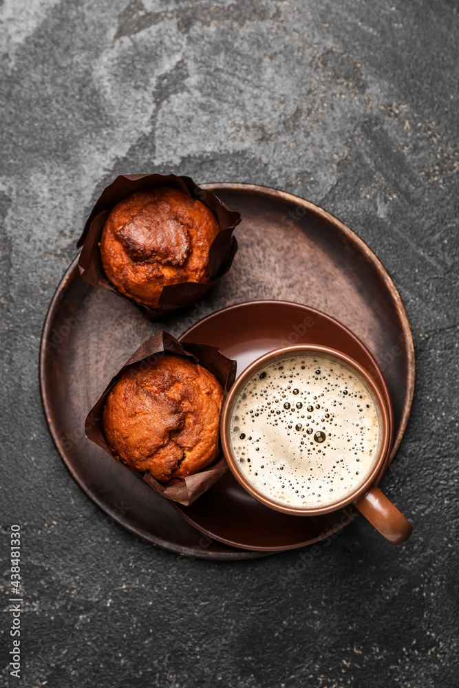 Cup of freshly brewed coffee and muffins on dark background