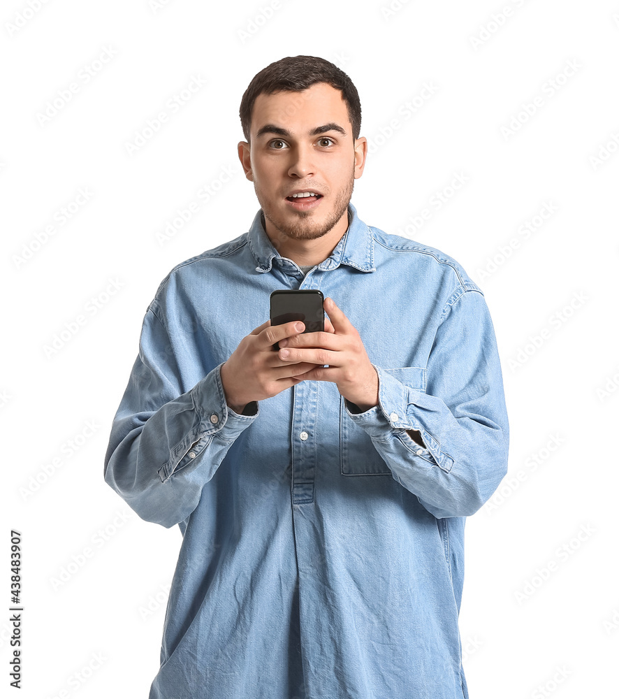 Surprised young man with mobile phone on white background