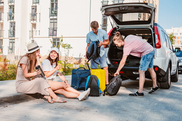 Wall Mural - friends load car trunk with baggage