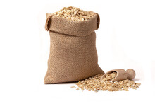 Oat Grains With Husk In Burlap Bag With Wooden Scoop Full Of Oatmeal Near Isolated On White Background