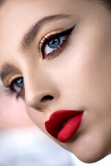 portrait of beauty model with bright color red lip makeup and creative arrows on eyes. beautiful you