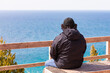 Man sitting on bench looking out over pristine Lake Michigan.