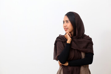 A portrait of happy asian muslim woman wearing a veil or hijab presenting and looking at empty space beside her. Isolated on white background with copy space