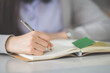 © EduLife Photos - Stock photo of a young teenage woman Asian college student in student uniform studying and writing on a notebook in a university classroom