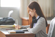 © EduLife Photos - Stock photo of a young teenage woman Asian college student in student uniform studying and writing on digital tablet in a university classroom