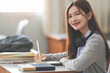 © EduLife Photos - Stock photo of a young teenage woman Asian college student in student uniform studying and writing on digital tablet in a university classroom