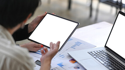 Cropped shot of businessman using digital table and sharing information to his colleagues.