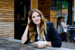 © Irina Schmidt - Young business woman drinking cappuccino and cup of coffee. Happy alone woman in outdoor cafe or restaurant on sunny summer day, break for lunch between meetings.
