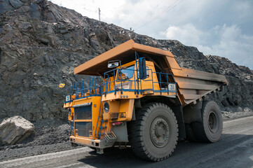 open cast dump truck drives alone industrial area of iron ore quarry