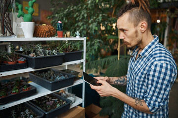 Wall Mural - Handsome young man using digital tablet computer at home