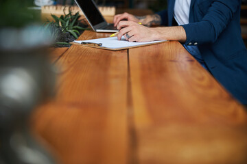 Wall Mural - Male person using laptop and taking notes at work