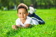 © Andrey_Arkusha - Little boy lies on green grass in a summer park