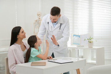 Sticker - Mother with daughter visiting pediatrician in hospital. Doctor giving high five to little girl