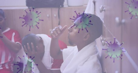 Poster - Animation of covid 19 cells over disappointed football players in changing rooms