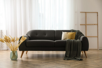 Sticker - Stylish living room interior with comfortable grey sofa and beautiful spikelets