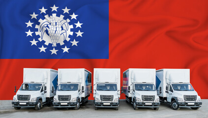 Myanmar flag in the background. Five new white trucks are parked in the parking lot. Truck, transport, freight transport. Freight and logistics concept