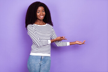 Wall Mural - Photo of sweet young lady point hold empty space wear striped pullover isolated on violet color background