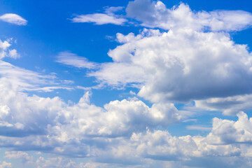 Blue bright sky with white cumulus clouds on a hot summer day