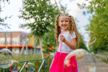 Wall Mural - little girl blows soap bubbles in the Park in the summer