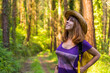 Traveler woman smiling with hat and looking at the forest pines, hiker lifestyle concept, copy and paste space, Basque Country forests. Spain