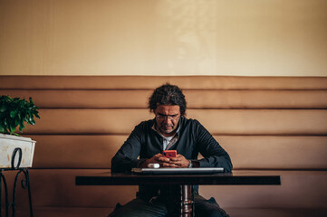 Senior hispanic cuban man using smartphone in a cafe
