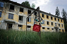 Some Sort Of Children´s Swing In Front Of An Abandoned Block