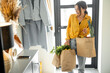 © rh2010 - Woman comes home with bags full of fresh groceries, shopping healthy food in eco-packaging. Concept of buying food online and delivering it home