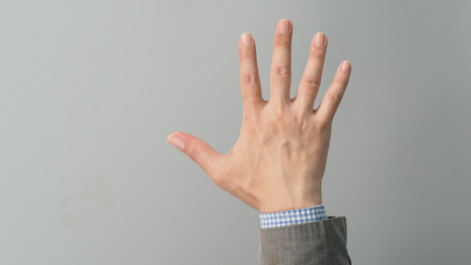 Wall Mural - Empty back hand and five finger count in grey suit color on grey background. Businessman topic.close up photo and studio shooting.