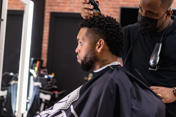 barber cutting hair for young people. in barber shop for all ages and styles.