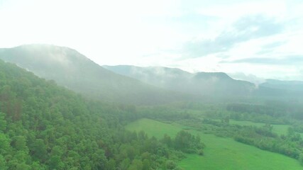 Wall Mural - Aerial video of clouds, mountains, forest and mountain river