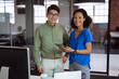 © wavebreak3 - Portrait of diverse male and female colleague holding tablet and smiling standing in office