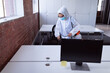 © wavebreak3 - Cleaner wearing ppe suit, glasses and mask disinfecting office workspace