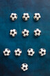 The most popular scheme of football players positions on the field (4-3-3) from chocolate cakes in the form of footballs on a beautiful blue table - top view, illustration