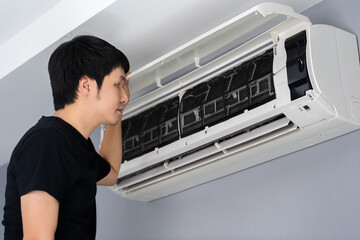 Wall Mural - man open the air conditioner indoor at home