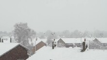 Snowy Roofs Of Residential UK Houses And Distant Treeline Grey Winter Sky