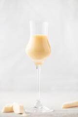 Wall Mural - Chocolate cream alcohol liqueur in a glass, pieces of white chocolate