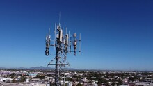 A Closeup And Detailed View Of Various GPS, Cellphone, 3G, 4G And 5G Equipped Telecommunication Tower As Seen On Clean Blue Sky With Copy Space