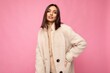 Caucasian photo of attractive self-confident stylish young brunette woman wearing autumn beaige warm coat isolated on pink background with empty space. Fashion concept