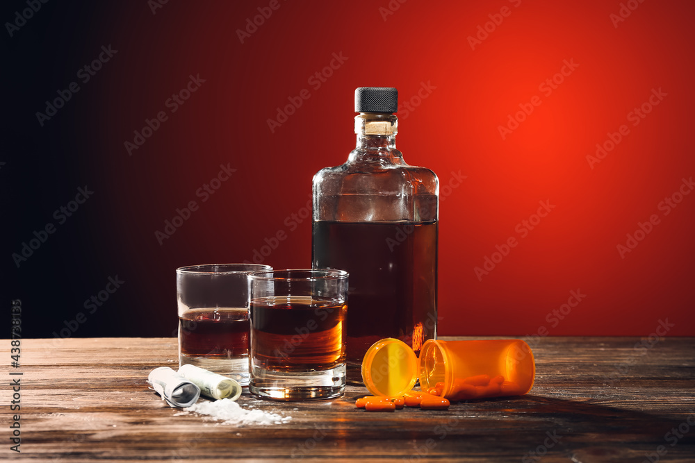 Alcohol, drugs, money and pills on table. Concept of addiction