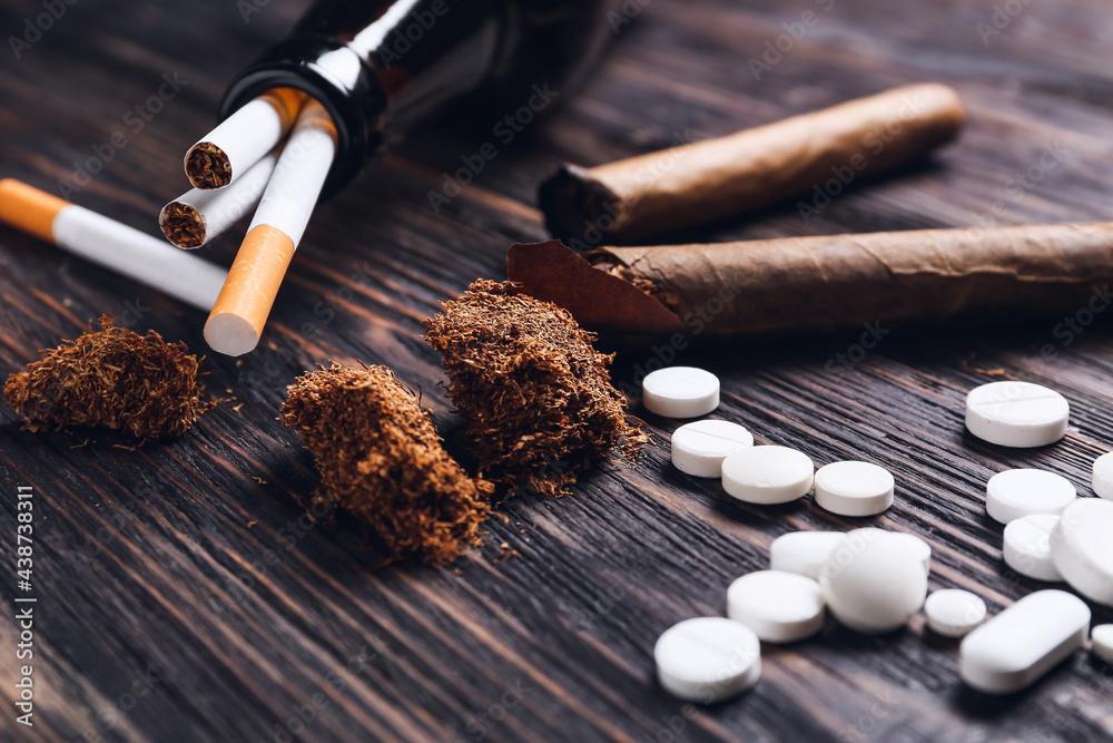 Drugs, alcohol, cigars and cigarettes on wooden background. Concept of addiction