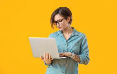 Female programmer with laptop on color background