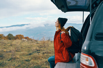 young traveler near the car in the autumn in the mountains