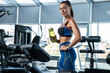 © nazarovsergey - Girl standing with water bottle after training at gym