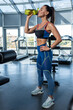 © nazarovsergey - Sporty girl drinking water after workout in gym