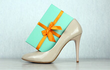 Green Gift Box With An Orange Bow In A Beige Women's Shoe