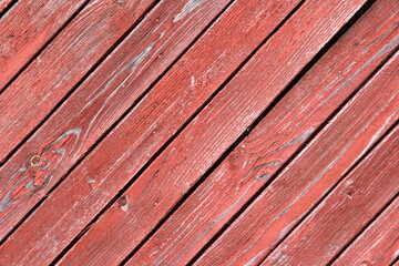 The background of the boards is painted with an old red color. Old red wooden board doors. Red rustic reclaimed wooden wall background.