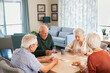 © Rido - Senior friends playing cards together at nursing home